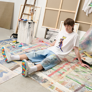 Lifestyle fashion visual presenting casual streetwear in an art studio, communicating creativity, comfort, and a relaxed, youthful attitude.