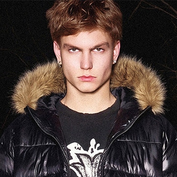 Model wearing a winter puffer jacket with a fur-trimmed hood for cold-weather styling and outerwear presentation