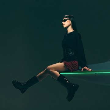 Mostra un outfit di moda contemporaneo e un atteggiamento, utilizzando una figura seduta per comunicare stile, sicurezza e mood in un contesto fashion o lifestyle.