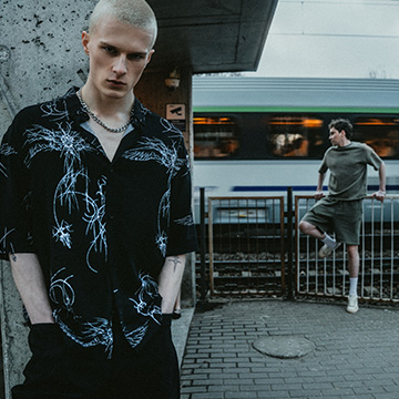 Urban streetwear campaign presenting casual outfits in a city transit setting, communicating a youthful, edgy lifestyle and everyday fashion for modern men.